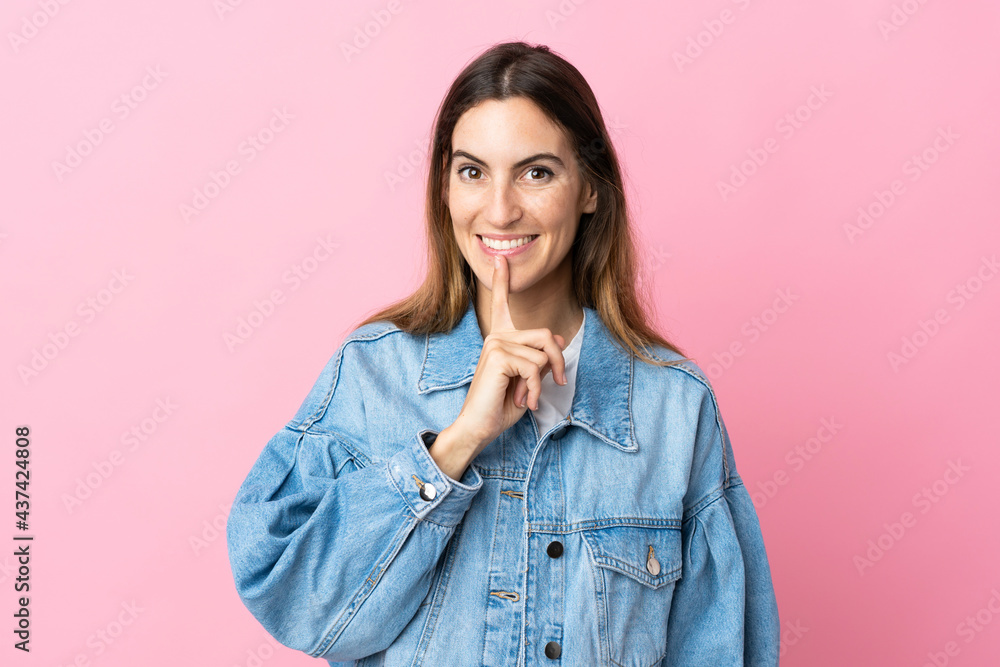 Young caucasian woman isolated on pink background showing a sign of silence gesture putting finger in mouth Young caucasian woman isolated on pink background showing a sign of silence gesture putting finger in mouth
