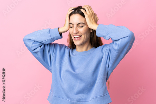 Young caucasian woman isolated on pink background laughing