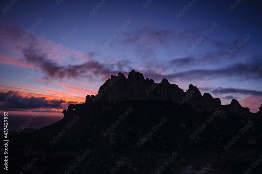 Montserrat west face and Roca Foradada seen from Sant Pau Vell de la Guàrdia at sunrise with red sky (Barcelona province, Catalonia, Spain) Montserrat west face and Roca Foradada seen from Sant Pau Vell de la Guàrdia at sunrise with red sky (Barcelona province, Catalonia, Spain)