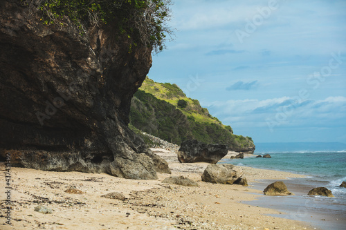 Picturesque sandy beach with rocks and rocks and azure sea, summer background