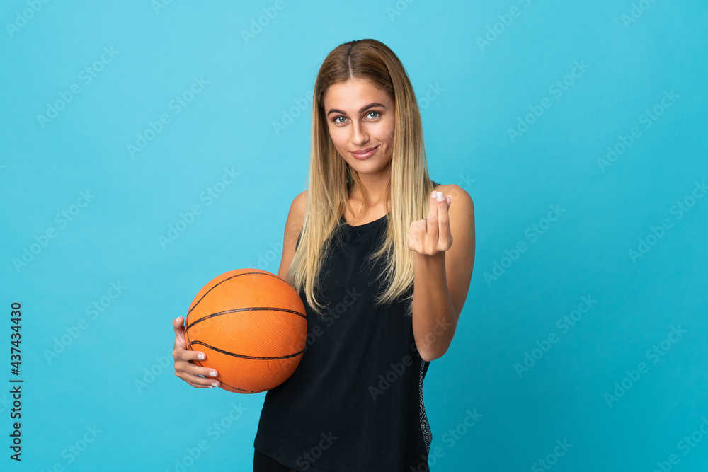 Young woman playing basketball  isolated on white background making money gesture