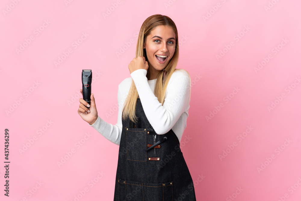 Young hairdresser woman isolated on pink background celebrating a victory Young hairdresser woman isolated on pink background celebrating a victory