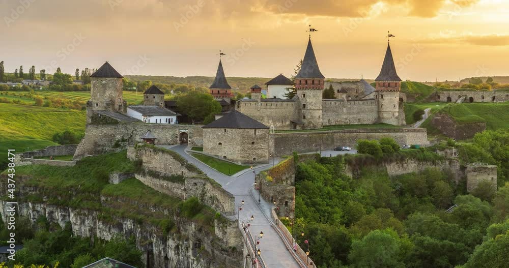 View of Kamianets-Podilskyi Castle at dusk with lights on against a dramatic sunset sky, Ukraine. Time Lapse Video. View of Kamianets-Podilskyi Castle at dusk with lights on against a dramatic sunset sky, Ukraine. Time Lapse Video.