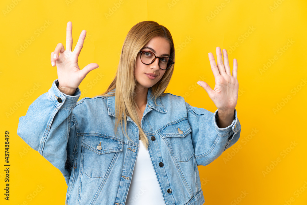 Young blonde woman isolated on yellow background counting eight with fingers Young blonde woman isolated on yellow background counting eight with fingers