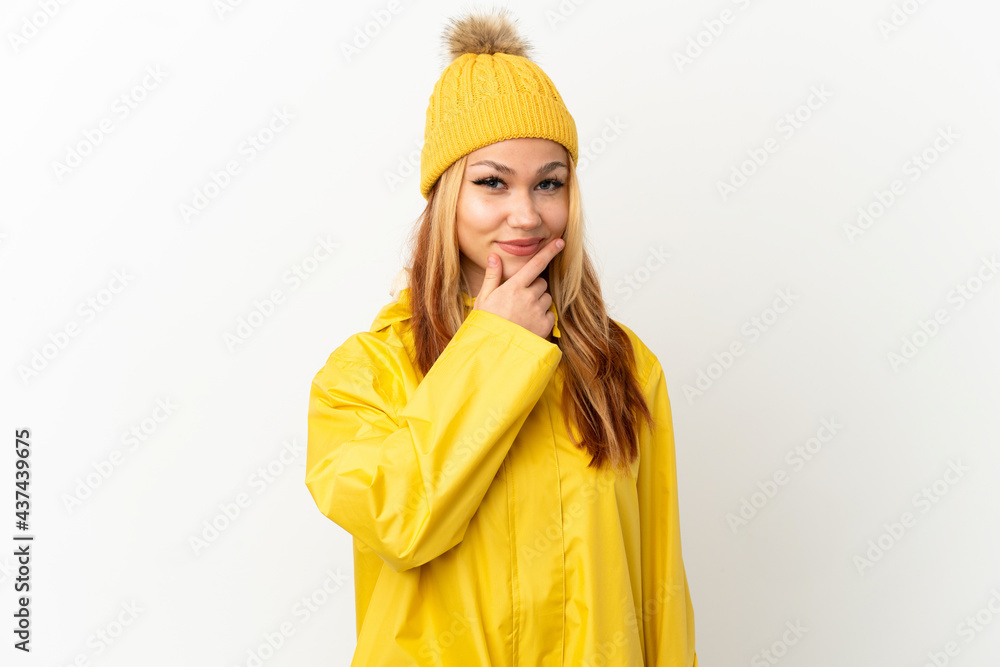 Teenager blonde girl wearing a rainproof coat over isolated white background thinking Teenager blonde girl wearing a rainproof coat over isolated white background thinking