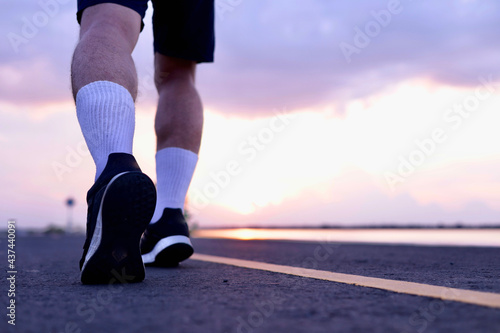 person running on the road and sun set