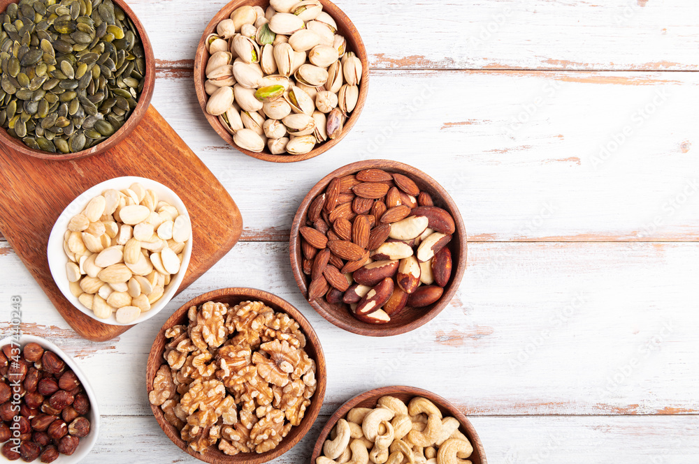 Different kind of nuts in wooden bowls Different kind of nuts in wooden bowls