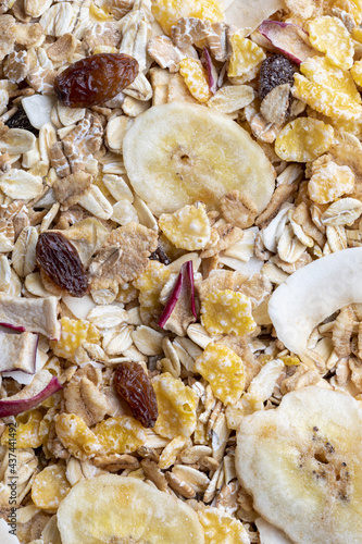Texture with whole grains for breakfast. Macro close-up. Muesli with dried fruits and dried fruits. Vertical portrait.