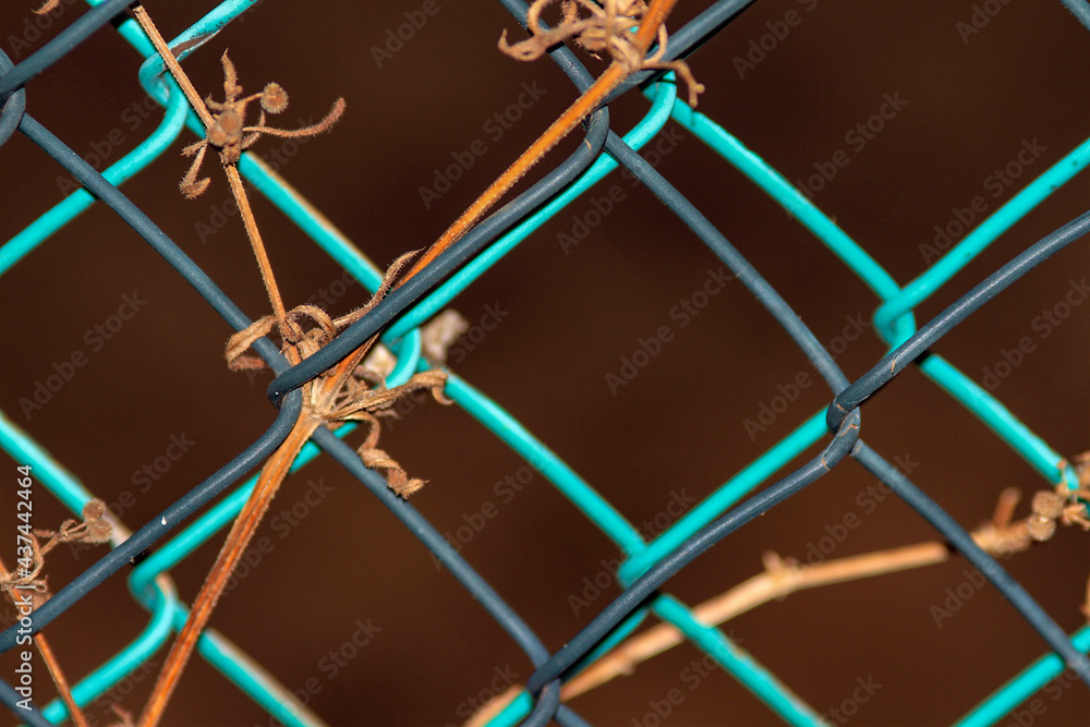 Close up of wire mesh illuminated by flash light, bluish colors on brown background.