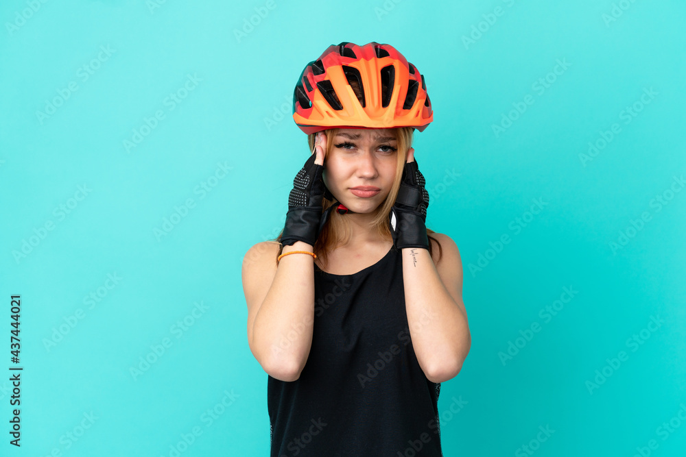Young cyclist girl over isolated blue background with headache Young cyclist girl over isolated blue background with headache