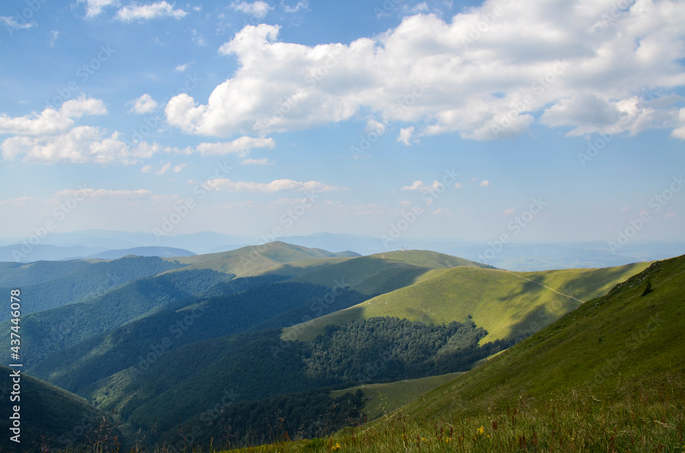 Majestic mountain range and rolling hills covered in green lush grass, bushes. Borzhava, Carpathian mountains, Ukraine