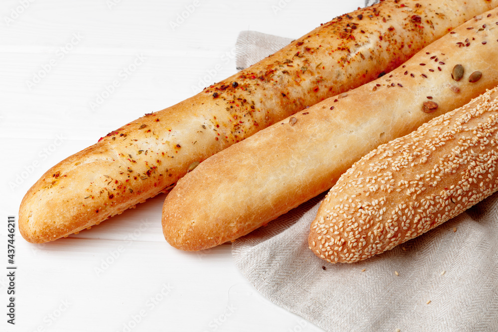 Fresh baguette bread on white wooden table