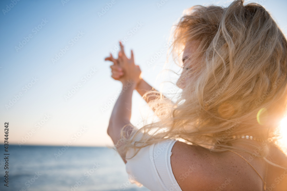 Obraz premium Girl in a white blouse and shorts on the background of the sea