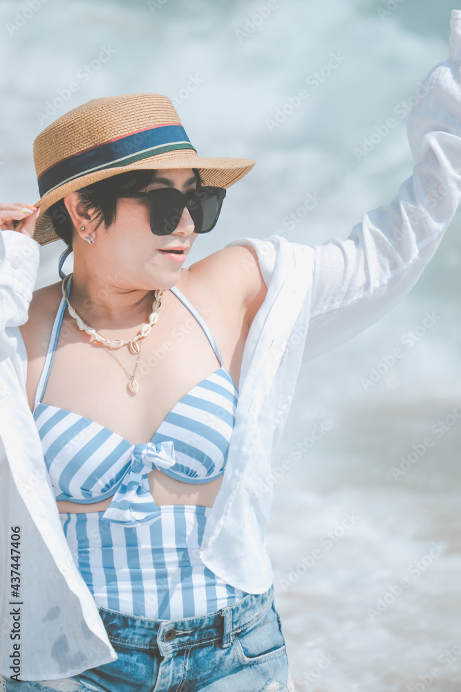 Happy traveller woman in white dress enjoys her tropical beach vacation, Asian girl in a swimsuit or bikini