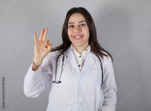 Young doctor woman isolated on gray background.