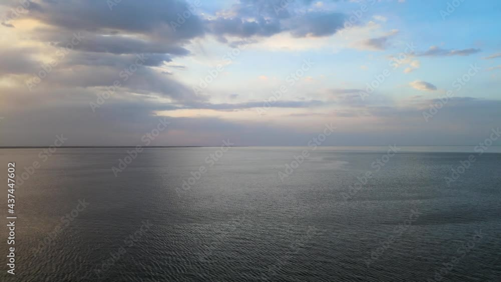 Drone flying above a very large lake that has small waves. The sky is full of colorful clouds.
Drone flying above a very large lake that has small waves. The sky is full of colorful clouds.