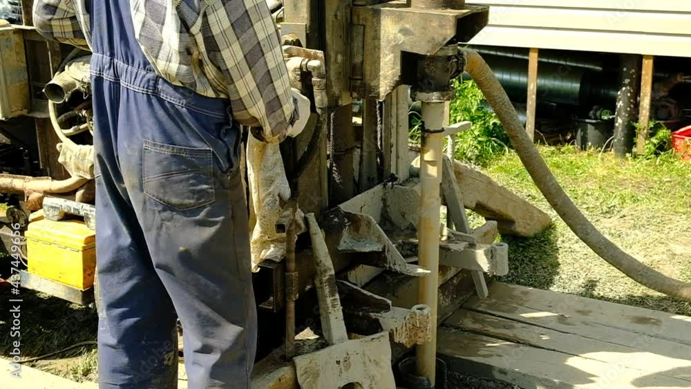 The drilling rig is drilling the ground. The worker started the mechanism of the well device. Search for water at depth. Russia. Day. Summer. The drilling rig is drilling the ground. The worker started the mechanism of the well device. Search for water at depth. Russia. Day. Summer.