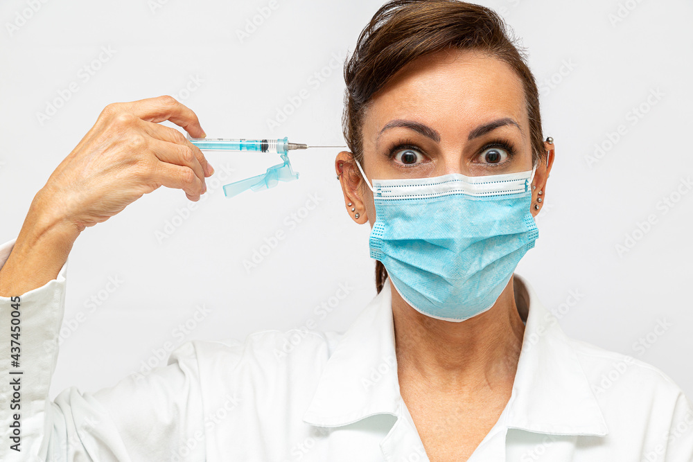 medica com com olhos arregalados com cara de assustada, segurando uma seringa com agulha e apontada para sua cabeça medica com com olhos arregalados com cara de assustada, segurando uma seringa com agulha e apontada para sua cabeça