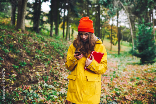 Young woman using smartphone in autumn forest