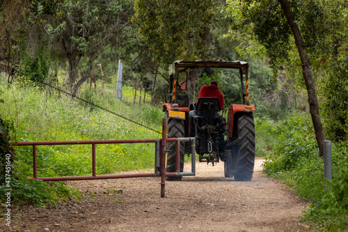 Tracktor on a trail with a gate.