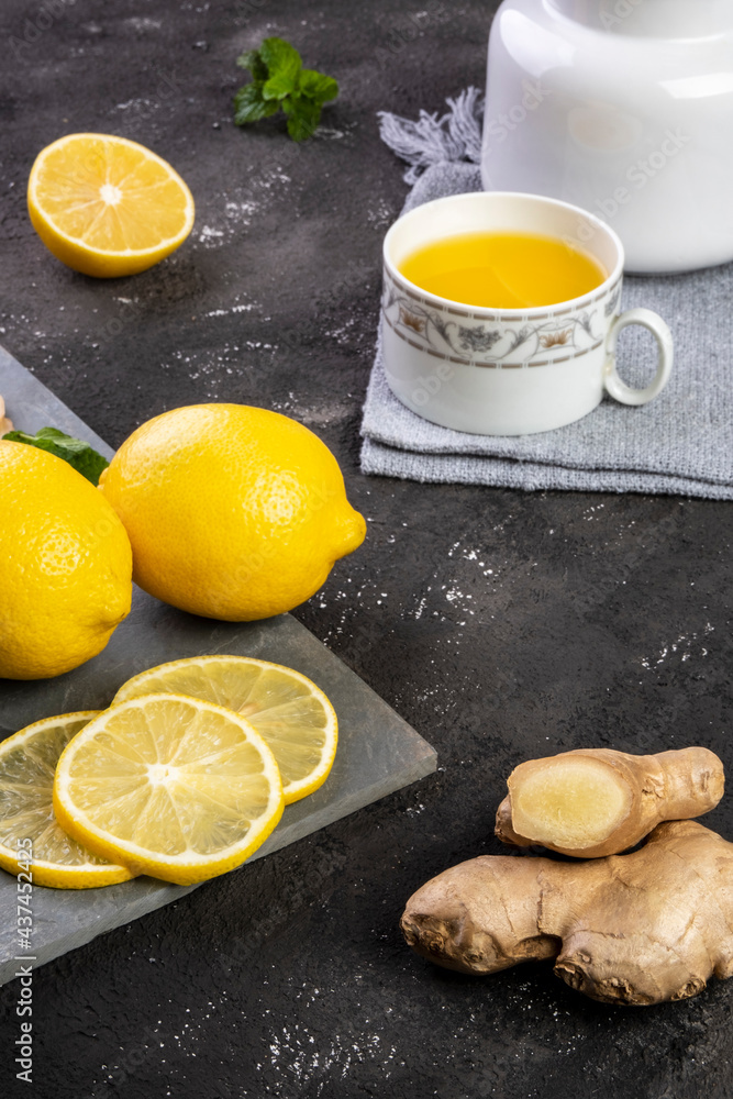 Sicilian lemon tea, ginger and mint leaves on slate stone Sicilian lemon tea, ginger and mint leaves on slate stone