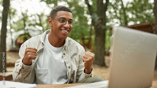 Smiling young african american man in front of laptop
