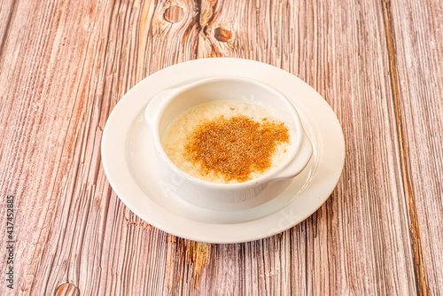 white porcelain bowl with rice pudding topped with brown sugar and cinnamon