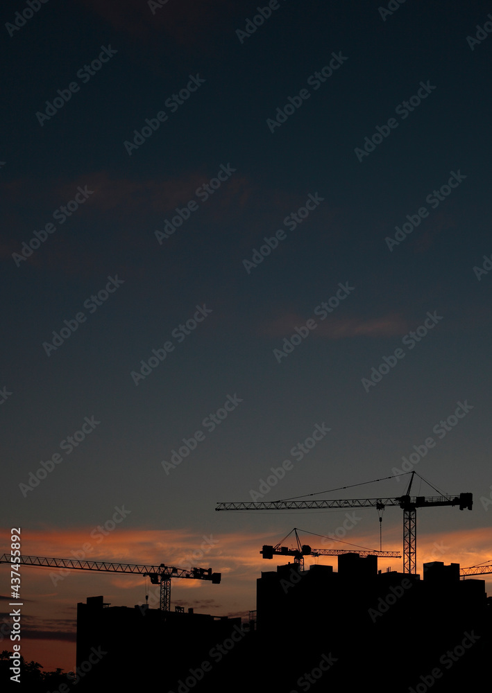 Construction cranes on the background of the sunset Construction cranes on the background of the sunset