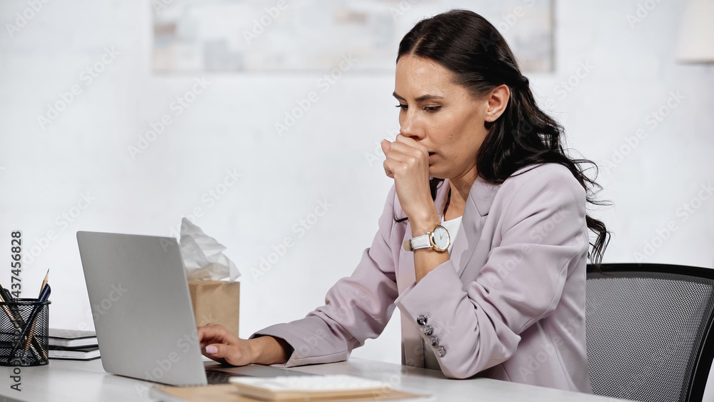 allergic businesswoman couching near laptop on desk allergic businesswoman couching near laptop on desk