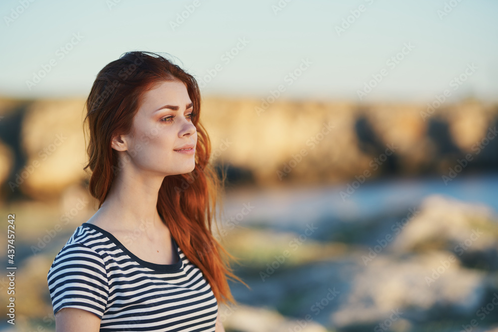 traveler in a striped T-shirt in the mountains near the river in nature