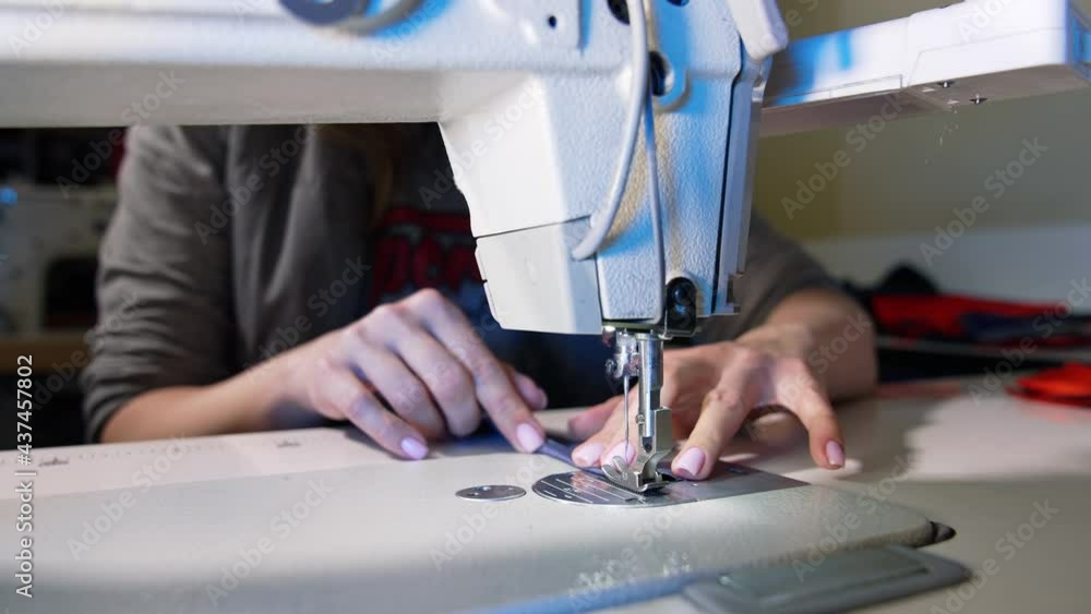 Process of sewing fabric on a sewing machine. Tailor working with