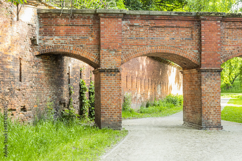 An arched red stone bridge in an old castle