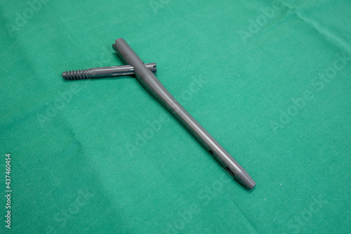 an explanted femoral nail lies on a green surgical drape photo