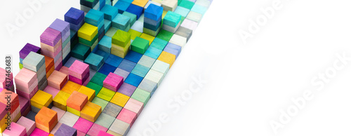 Spectrum of stacked multi-colored wooden blocks with white space in front. Background or cover for something creative, diverse, expanding,  rising or growing.  slanted view. photo