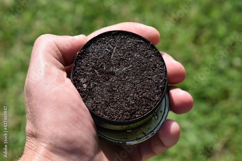 Slika na platnu Can of Chewing Tobacco Held in a Hand