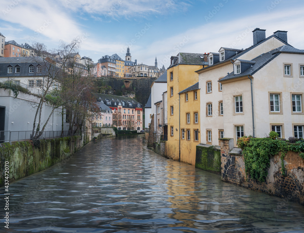 Naklejka premium Alzette River and the Grund district with St Michaels Church on background - Luxembourg City, Luxembourg