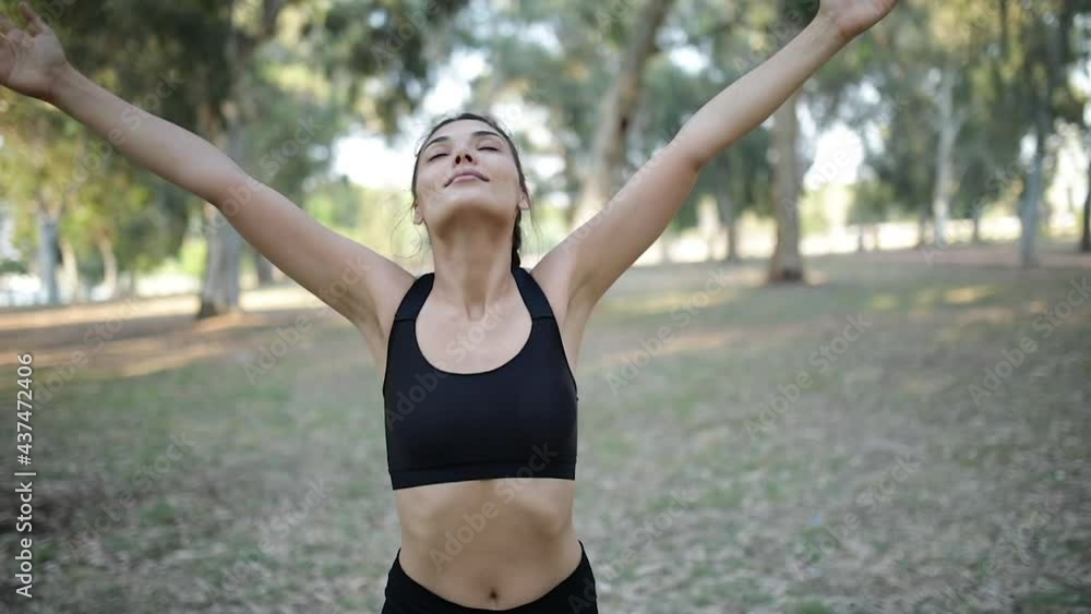 beautiful young woman in sportswear hands up and getting fresh air beautiful young woman in sportswear hands up and getting fresh air