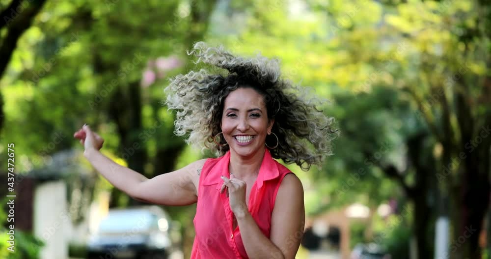 Happy hispanic woman dancing outside celebrating life Happy hispanic woman dancing outside celebrating life