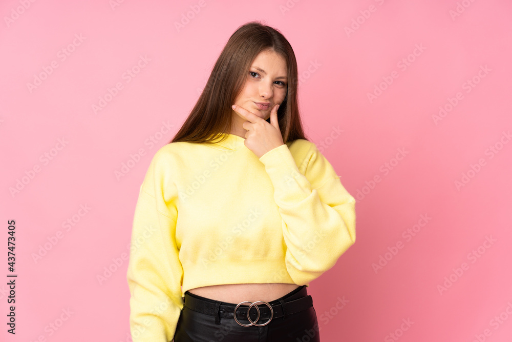 Teenager caucasian girl isolated on pink background having doubts Teenager caucasian girl isolated on pink background having doubts