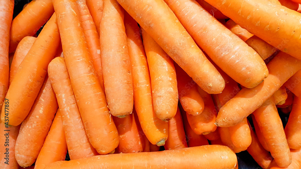 Carrots placed in a stall for sale.Macro Photo spring food vegetable carrot. Texture background of fresh large orange carrots. Product Image Vegetable Root Carrot.