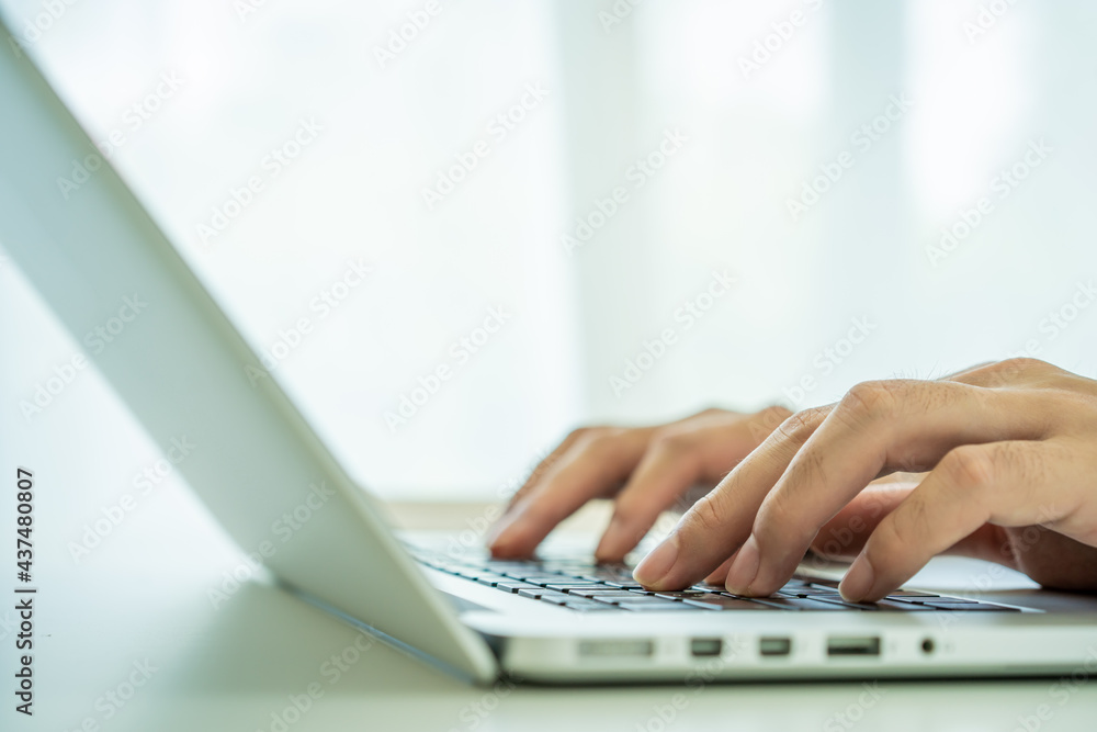 Unrecognizable Asian young man working and typing on the laptop computer keyboard. Unrecognizable Asian young man working and typing on the laptop computer keyboard.
