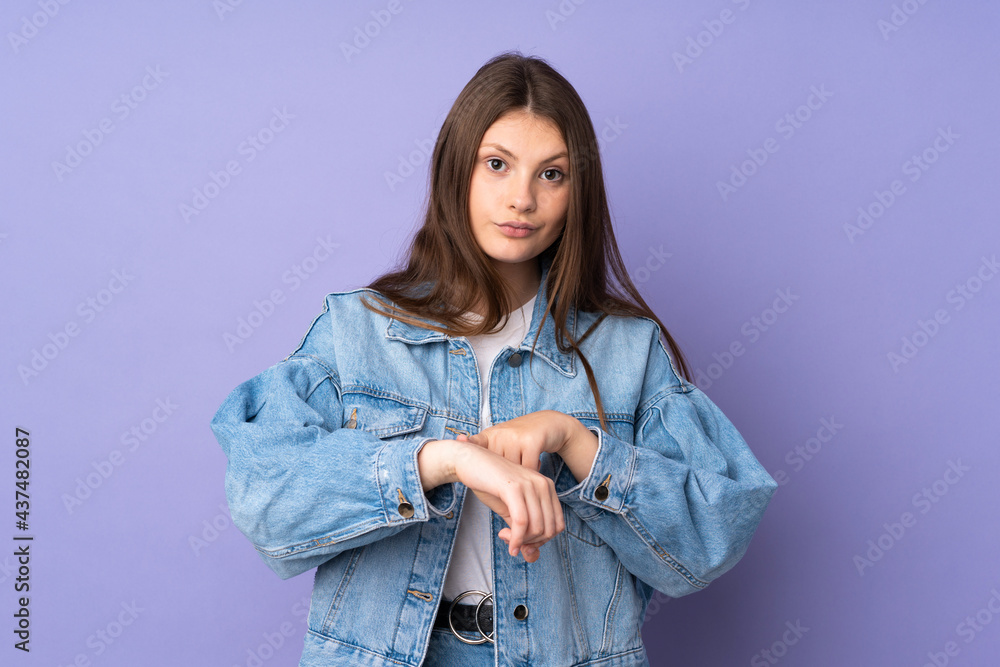 Teenager caucasian girl isolated on purple background making the gesture of being late