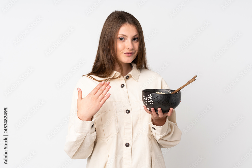 Teenager caucasian girl isolated on white background inviting to come with hand. Happy that you came while holding a bowl of noodles with chopsticks Teenager caucasian girl isolated on white background inviting to come with hand. Happy that you came while holding a bowl of noodles with chopsticks