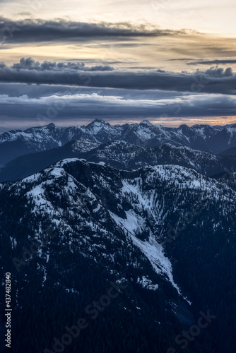 Aerial View from Airplane of Canadian Mountain Landscape in Spring time. Colorful Sunset Sky. North of Vancouver, British Columbia, Canada. Dark Moody Art Render