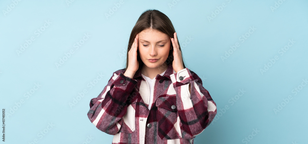 Teenager caucasian girl isolated on blue background with headache