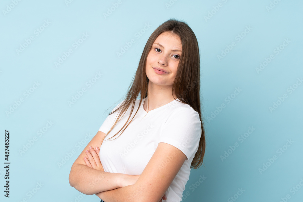 Teenager caucasian girl isolated on blue background with arms crossed and looking forward Teenager caucasian girl isolated on blue background with arms crossed and looking forward