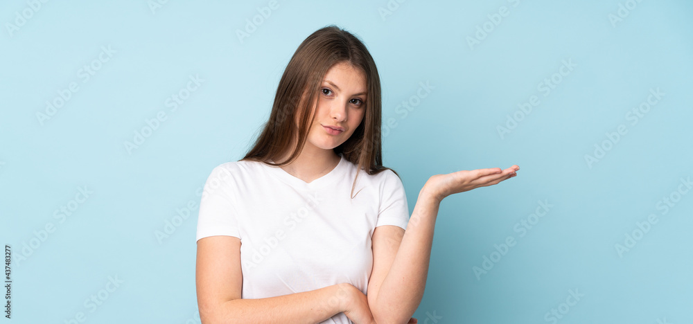Teenager caucasian girl isolated on blue background having doubts Teenager caucasian girl isolated on blue background having doubts