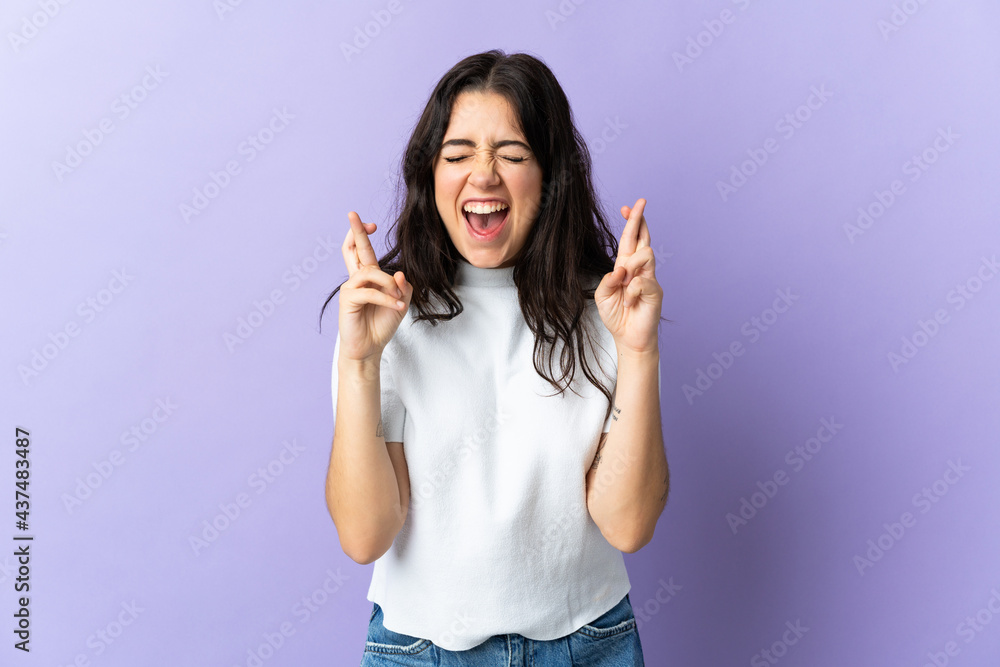 Young caucasian woman isolated on purple background with fingers crossing Young caucasian woman isolated on purple background with fingers crossing