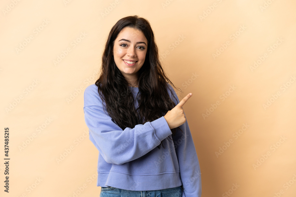 Young caucasian woman over isolated background pointing to the side to present a product Young caucasian woman over isolated background pointing to the side to present a product
