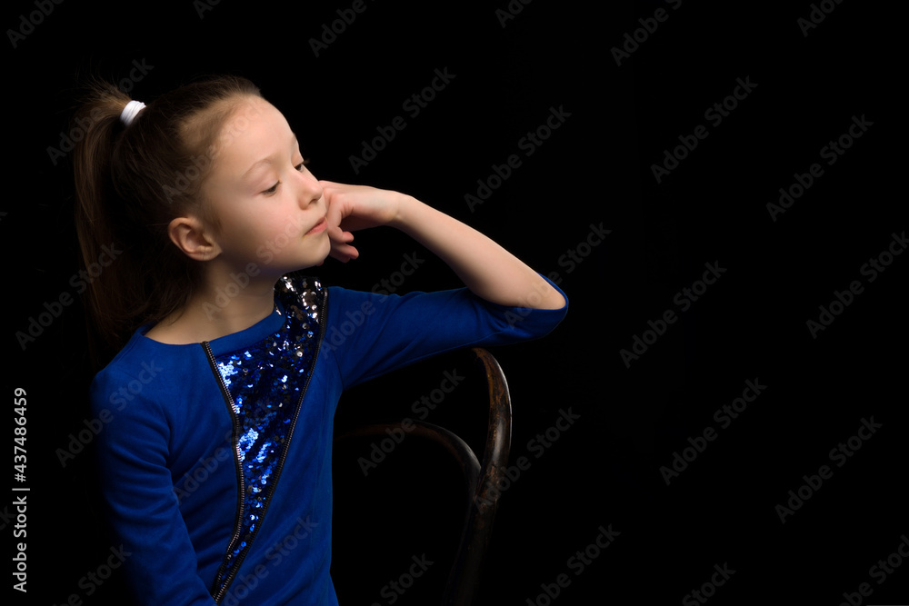 A profile portrait of a pensive little girl.On a black background. A profile portrait of a pensive little girl.On a black background.